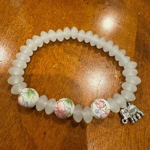 White Beaded Bracelet with Floral Accents and Elephant Charm